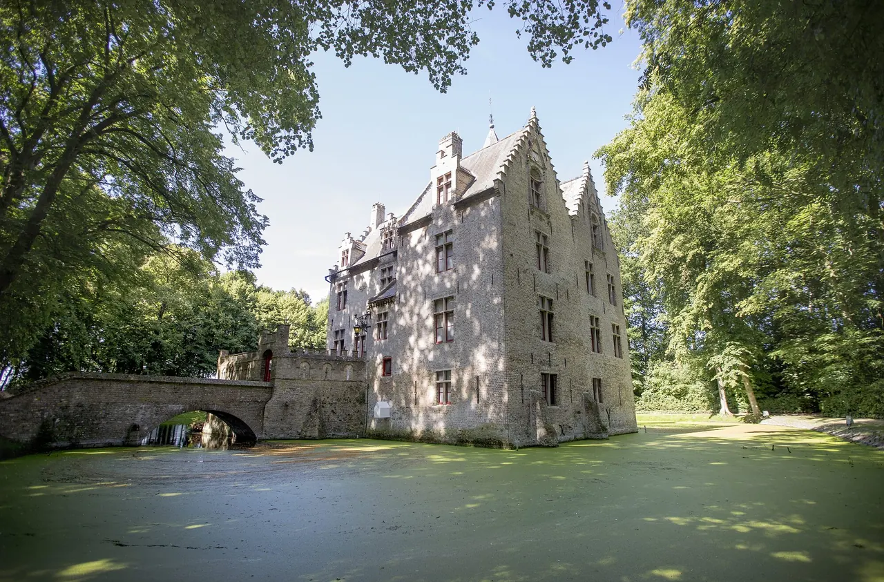 Het kasteel van Beauvoorde weerspiegeld in de slotgracht.