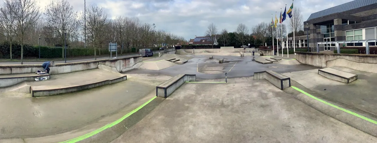 De skateplaza met betonnen bowls en hellingen.