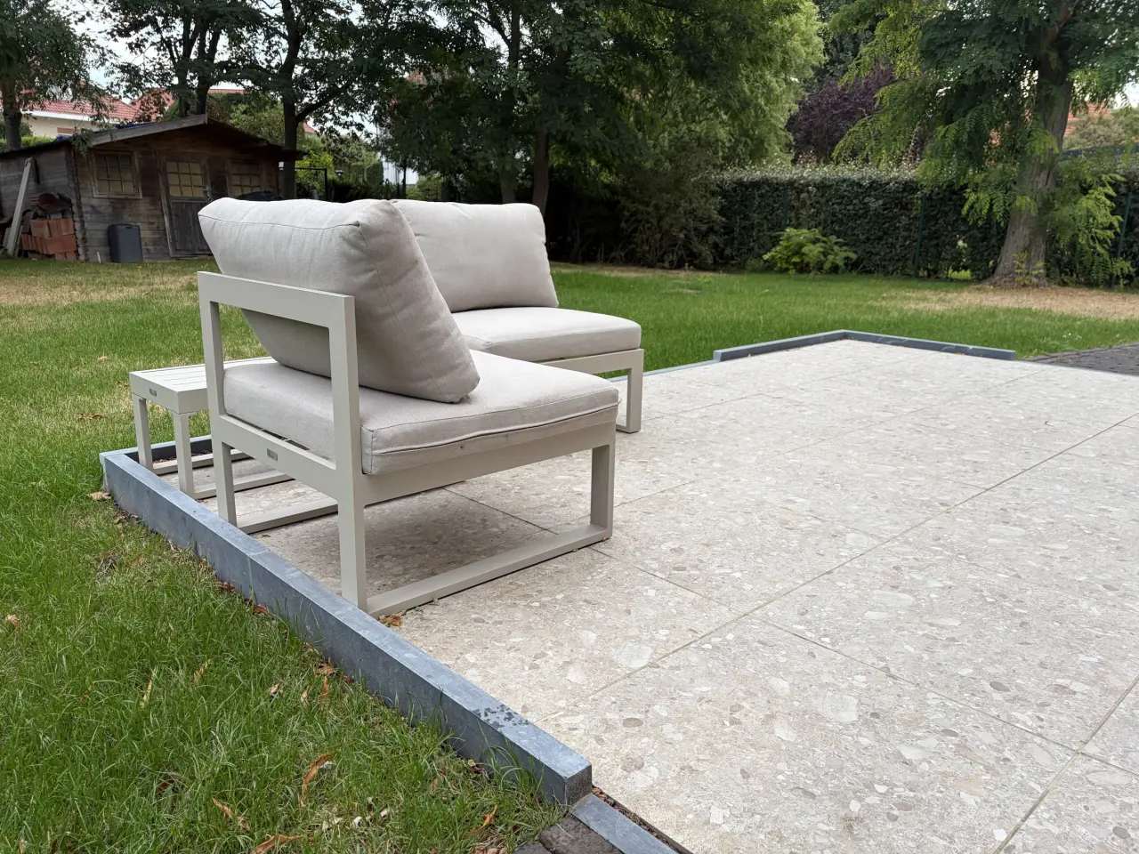 Het terras aan de achterzijde met een opstaande boord langs de rand.