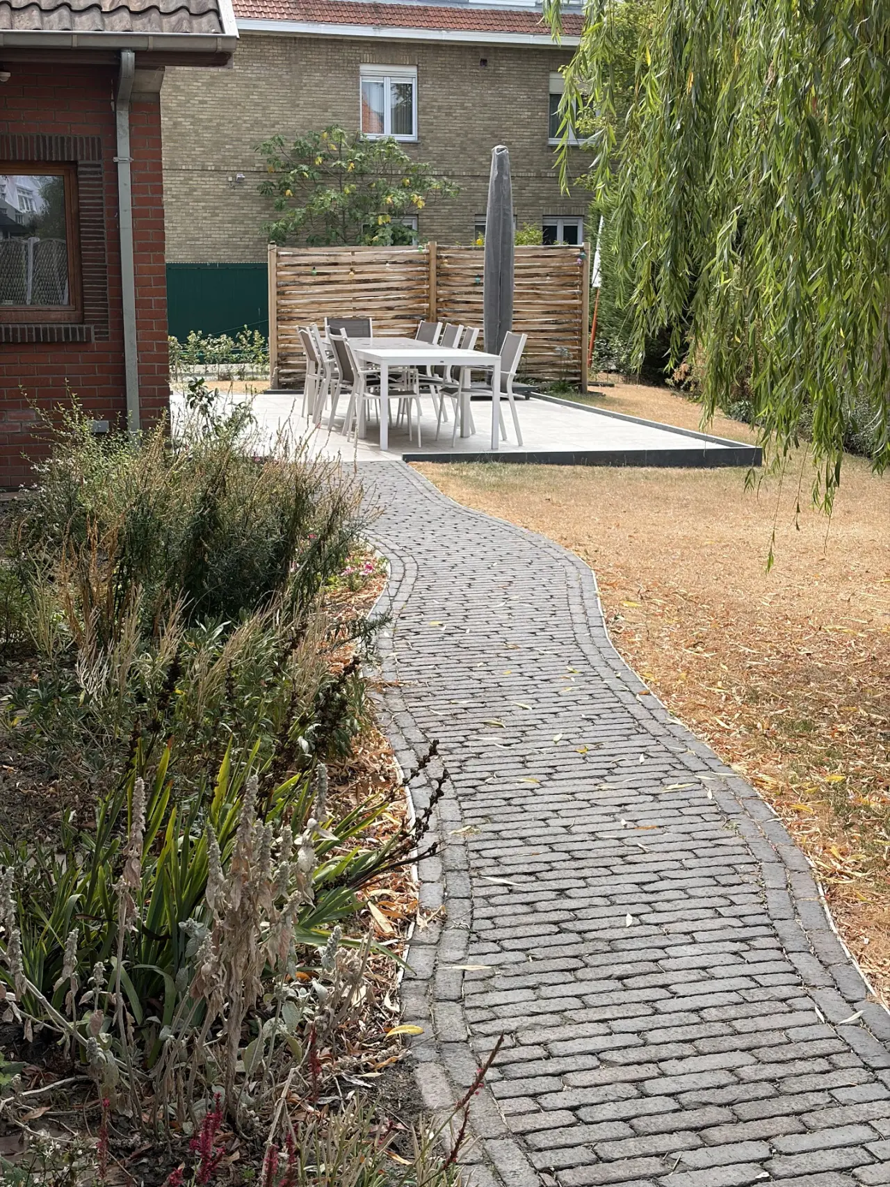 Het brede tuinpad dat zonder obstakels rond de woning loopt.